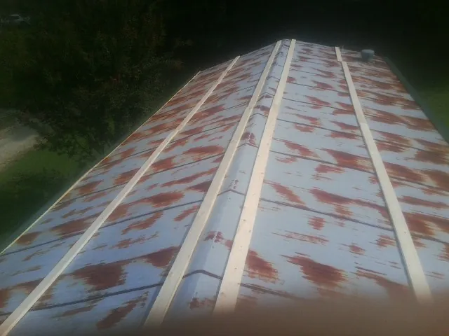Rusted metal roof panels with new wood purlins before replacement — Storm Damage Roof Repair in Port Orchard by Roofing Brothers