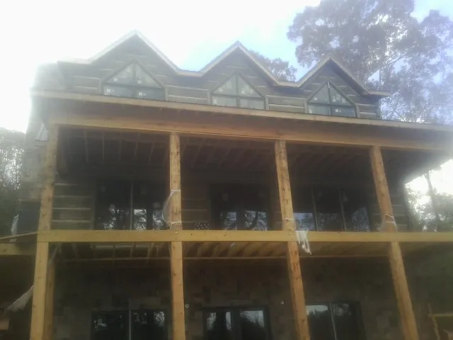 Dormers and porch framing on a large log home under construction — Roof Coating work by our crew in Port Orchard